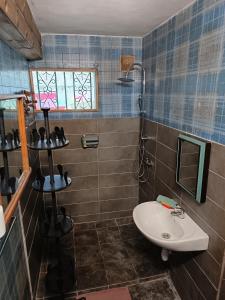 a bathroom with a sink and a toilet and a mirror at Le Tuléar - Aux 4 coins du monde in Saint-Pierre