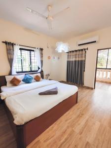 Una cama grande en una habitación con suelo de madera. en 2bhk Villa - Calangute, en Candolim