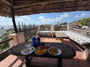 拉穆Wildebeeste Lamu的阳台上的一张桌子上摆着两盘食物