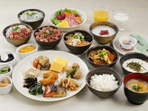 川崎市にあるリッチモンドホテルプレミア武蔵小杉のさまざまな種類の食べ物が入ったボウルが置かれたテーブル