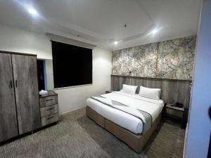 a bedroom with a large bed and a flat screen tv at فندق الخلفاء الفيصلية الفندقية in Mecca +23 photos