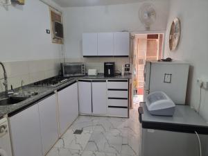 a small kitchen with white cabinets and a refrigerator at Adream partment in Luxor in Luxor