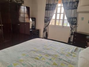 a bedroom with a bed with a dresser and a window at Adream partment in Luxor in Luxor