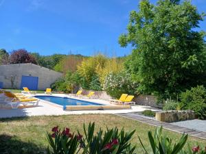 a swimming pool in a garden with yellow lounge chairs at Gîte Jasmin in Plavilla