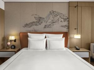 a bedroom with a large bed with white pillows at Swissotel Beijing Hong Kong Macau Center - 1 min to subway in Beijing