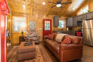 a living room with a leather couch and a kitchen at WiFi & Waterfront - Creeksong -Red River Gorge KY in Rogers