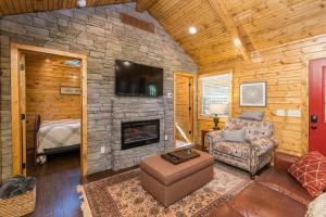 a living room with a couch and a fireplace at WiFi & Waterfront - Creeksong -Red River Gorge KY in Rogers +35 photos