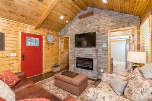 a living room with a fireplace and a red door at WiFi & Waterfront - Creeksong -Red River Gorge KY in Rogers