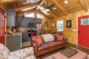 a living room with a leather couch and a kitchen at WiFi & Waterfront - Creeksong -Red River Gorge KY in Rogers