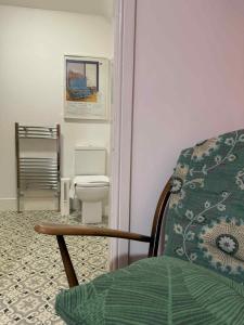 a bathroom with a toilet and a chair in it at The Cross Inn in Hebden Bridge