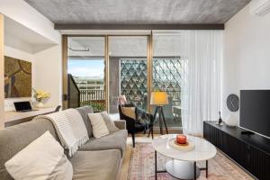 ein Wohnzimmer mit Couch und Tisch in der Unterkunft Geelong Central Apartment with Short & Long Stays in Geelong