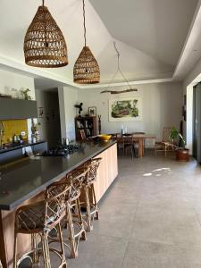 a kitchen with a bar with chairs and a dining room at Belle Villa de Grand Baie in Midlands Station +8 photos