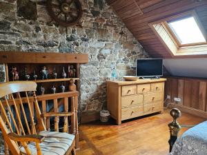 ein Schlafzimmer mit einer Steinwand und einem Holzstuhl in der Unterkunft Rose by the sea - Beach front sea views in Hirel