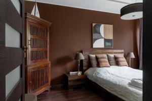 a bedroom with a bed and a wooden cabinet at Baltic Breeze Lodge in Gdynia