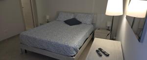 カターニアにあるShort Location Paratore Casa Melinaのランプ2つとテーブルが備わるドミトリールームのベッド1台分です。