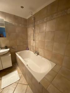 a white bath tub in a bathroom with a sink at Azure Horizon in Hannover