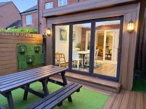 a wooden bench sitting on a patio with a table at Harwell Haven Retreat in Chilton