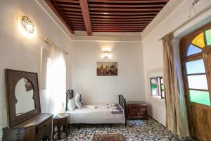 une chambre avec un lit, un miroir et une fenêtre dans l'établissement Dar El Kendil, à Fès