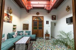 - un salon avec un canapé bleu et une porte en bois dans l'établissement Dar El Kendil, à Fès