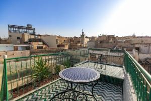 une table sur un balcon avec vue sur une ville dans l'établissement Dar El Kendil, à Fès