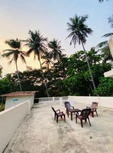 4 sillas y una mesa en un patio con palmeras en 2bhk Villa - Calangute, en Candolim