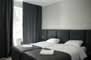 a bedroom with a large bed with two towels on it at Elata Aparts in Skhidnitsa +48 photos