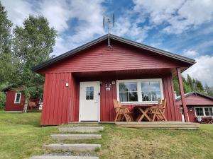 a red shed with a porch and two chairs at Tärnaby Sportstugor in Tärnaby