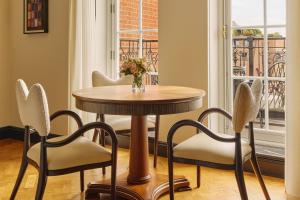 a table and chairs with a vase of flowers on it at Claridge's, Maybourne in London
