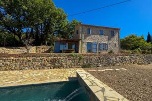 una casa de piedra con una piscina frente a ella en Provençal Escape, en Montauroux