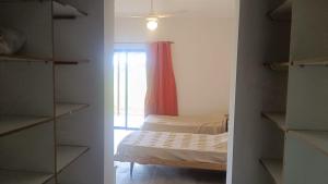 a small bedroom with a bed and a window at FincaMora in Colonia del Sacramento