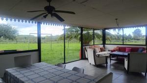 a living room with a ceiling fan and a large window at FincaMora in Colonia del Sacramento