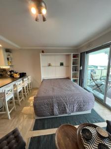 a bedroom with a bed and a table and a kitchen at Le Lido - Piscine, proche plage in Cros-de-Cagnes