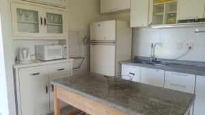 a kitchen with white cabinets and a counter top at FincaMora in Colonia del Sacramento +21 photos