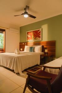 a bedroom with a bed and a ceiling fan at Pousada Todas as Luas in Ubatuba +40 photos
