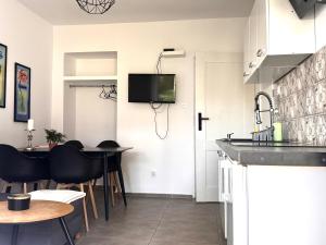 a kitchen with a sink and a table with chairs at Familly Apartament 6 in Międzyzdroje +1 photo