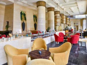 a lobby with chairs and a table and a bar at Raffles Dubai in Dubai