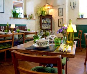 a wooden table with glasses and a plate on it at The Bellachroy in Dervaig