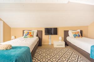 two beds in a room with a flat screen tv at Le 3 de Coeur Annecy in Annecy
