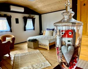 a glass jar with hearts and a room with a bed at Szegfű33 Vendégház in Zebegény