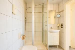 a bathroom with a shower with a toilet and a sink at Gästehaus Marietta in Osann-Monzel +32 photos
