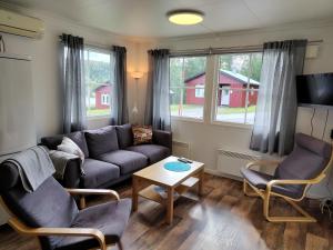 a living room with a couch and two chairs and a table at Tärnaby Sportstugor in Tärnaby