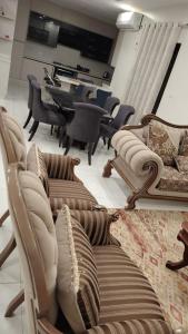 un salon avec des chaises et une table avec un piano dans l'établissement شقه في حي الراهبات, à Irbid