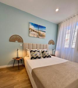 a bedroom with a large bed with blue walls at Water Vibes Porto by MyMoradia in Porto
