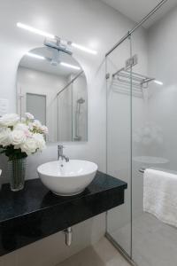 a bathroom with a sink and a glass shower at The Writeriana de Lumière in Ho Chi Minh City