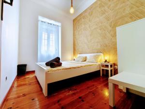 a bedroom with a bed with a teddy bear sitting on it at Areeiro Urban Rooms in Lisbon +13 photos