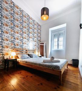 a bedroom with a large bed with a wall at Areeiro Urban Rooms in Lisbon