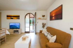 a living room with a couch and a tv at Villa Asia Deluxe in Castiglione del Lago