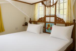 two white pillows sitting on a bed in a room at Outdoor Cinema Group Friendly Retreat in Pingwe