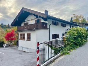 a white house with a fence in front of it at Ferienwohnung Mangfall - Berge, Natur und Ruhe in Hausham