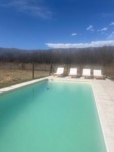 a swimming pool with two lounge chairs at Ranchos de la Tata in Las Calles